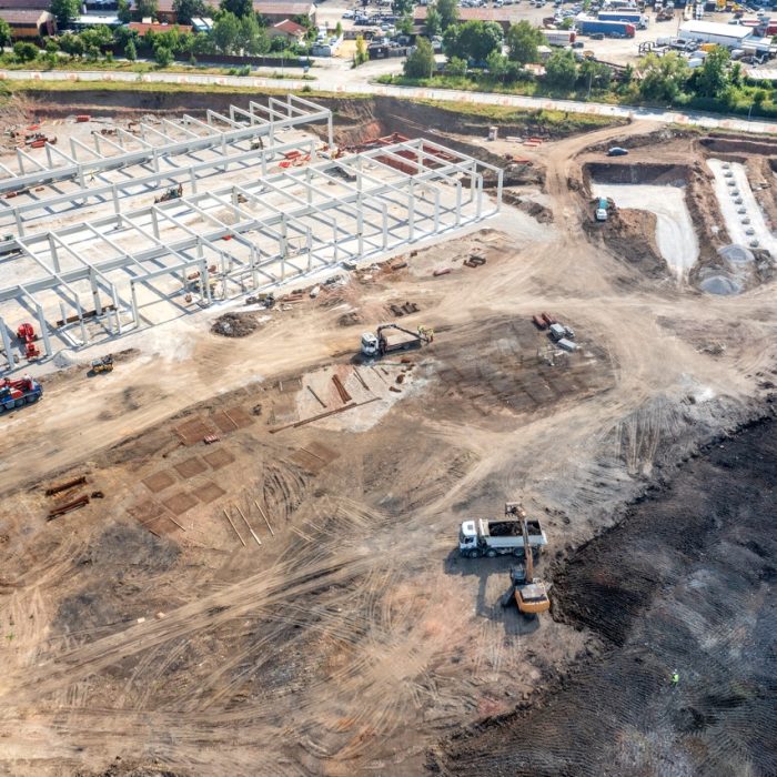 Aerial top view of huge construction site with many working heavy machines