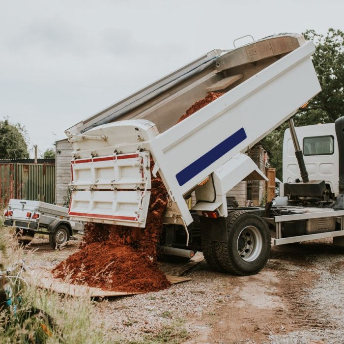 Dump truck unloading soil on a construction site