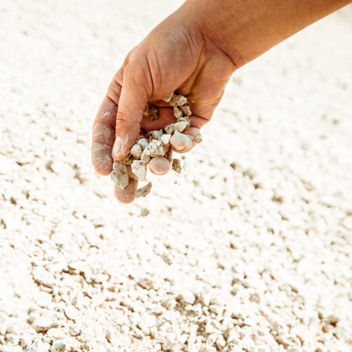 side view hands with white stones. rough light, close up